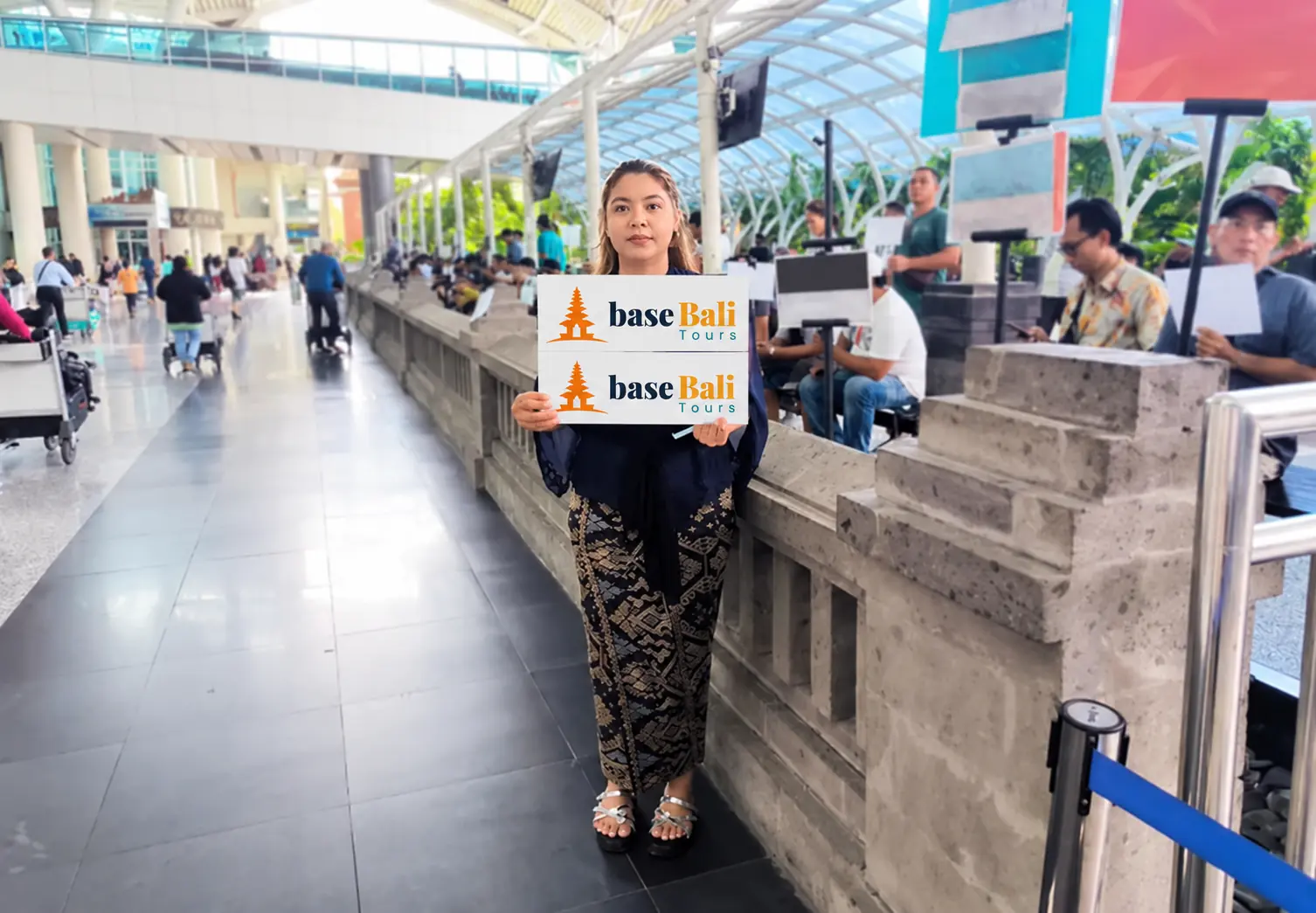 Woman holding a baseBali Tours welcome sign in an airport terminal