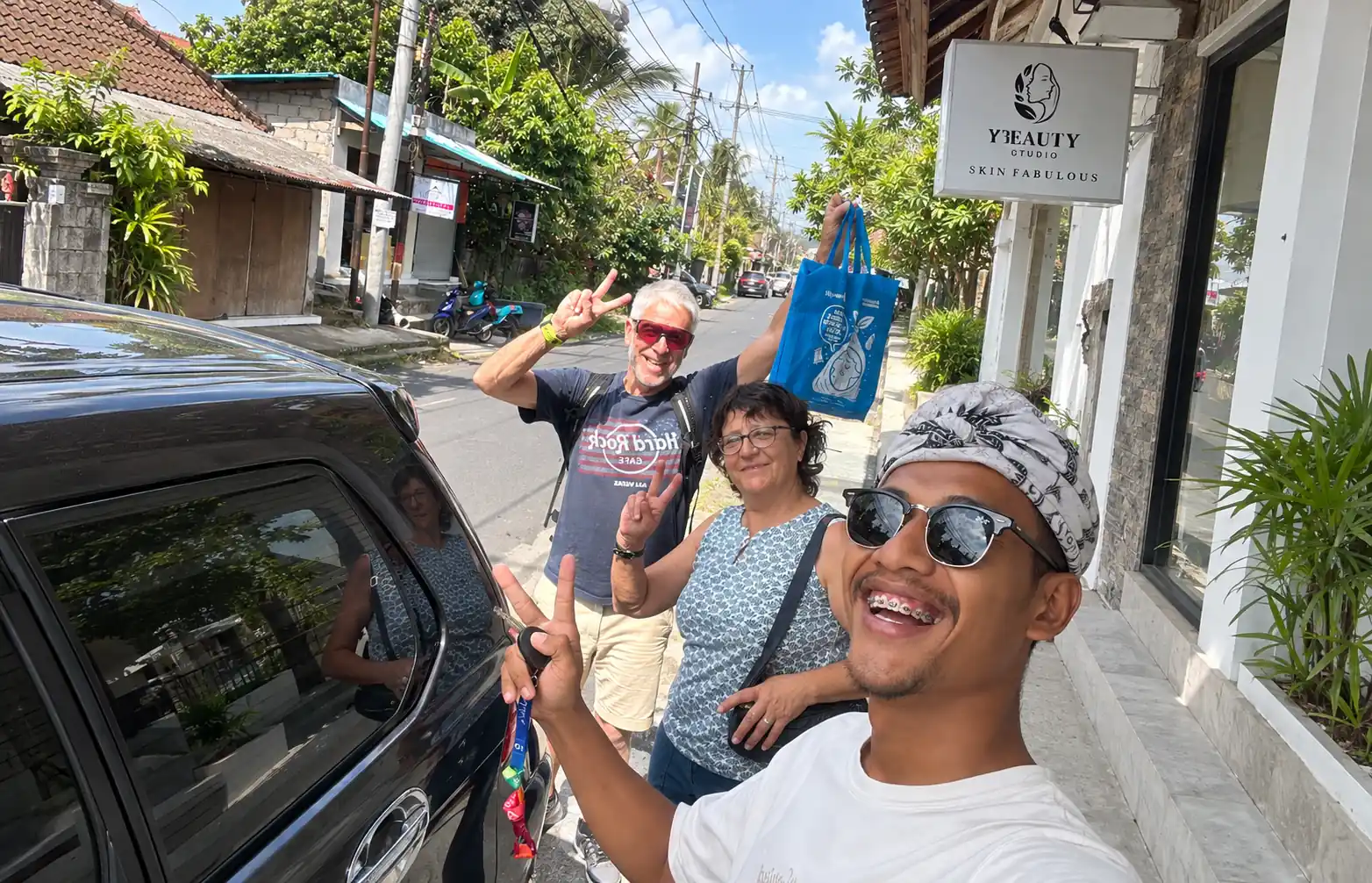 baseBali Tours driver and two guests beside a car in Bali