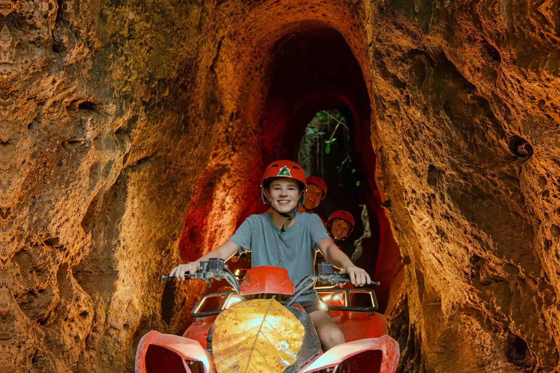 Helmeted riders on ATVs inside the Kuber cave