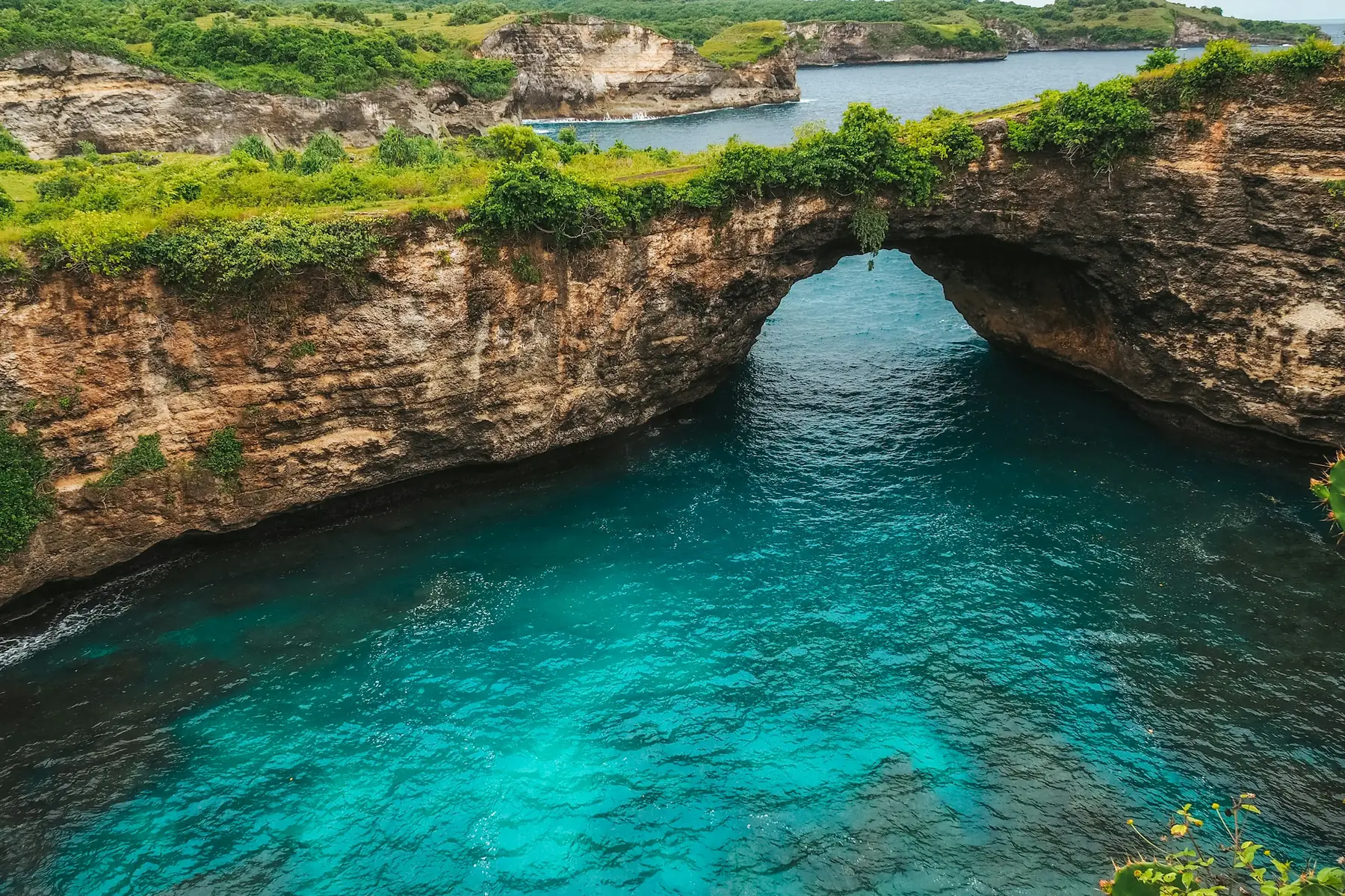 Broken Beach's natural limestone arch enclosing blue water on West Nusa Penida